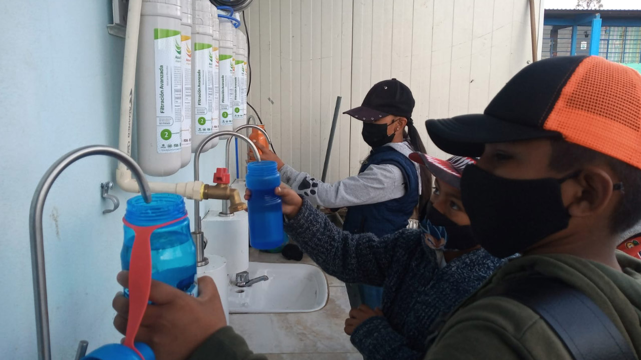 Niños tomando agua de purificador Accua-Flex